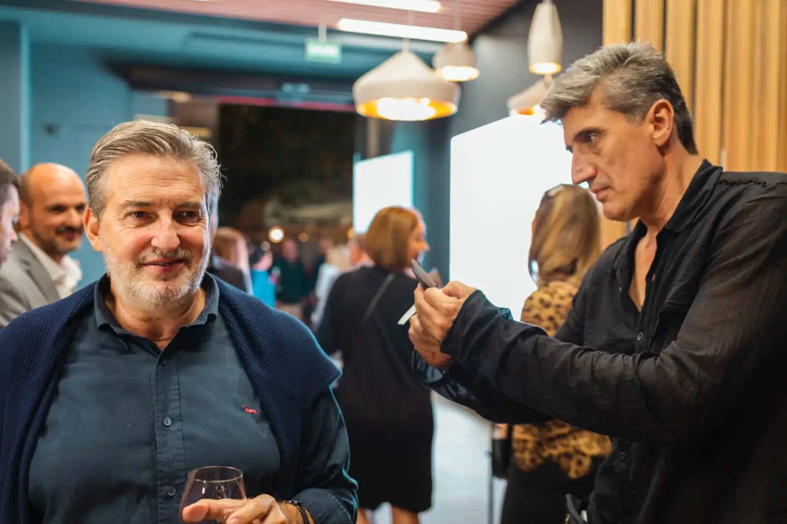 Invité d'un événement d'entreprise tenant une coupe de champagne pendant la découpe d'une silhouette